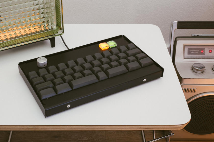 Keyboard sitting on a table next to a stereo and a lamp