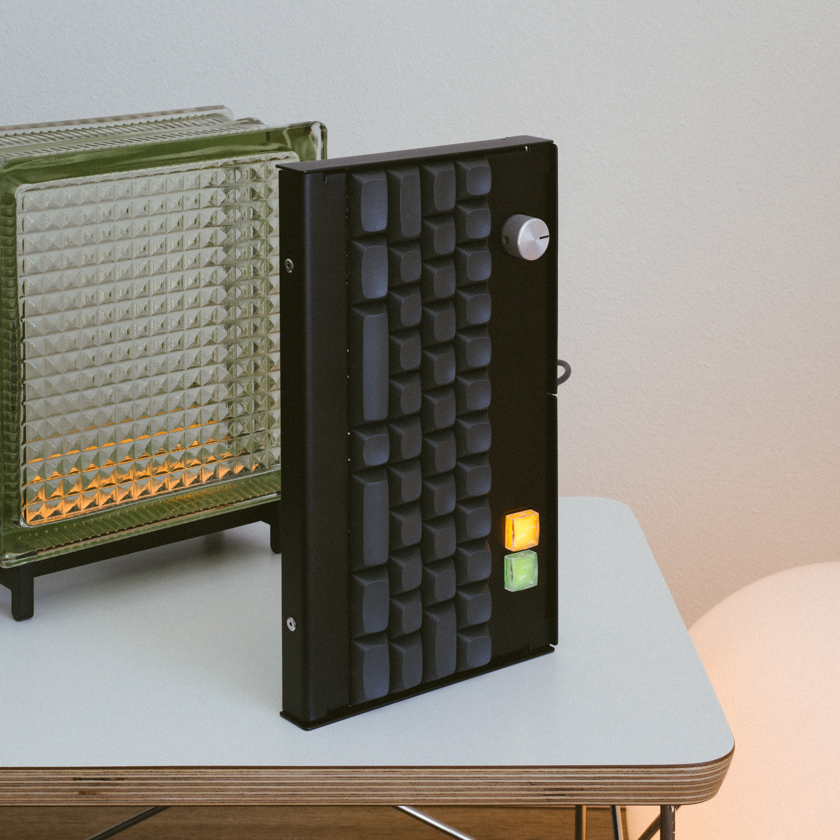 Keyboard standing on-end on a table next to two lamps